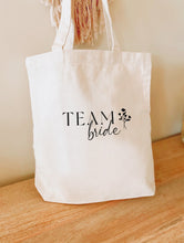 Charger l&#39;image dans la galerie, Tote Bag - Team bride
< img src =https://cdn.shopify.com/s/files/1/0264/4331/7284/files/TYPO_TYPO_TYPO_2020_f0ea7750-d775-4365-9ad6-22312b875fea.jpg?v=1609341423